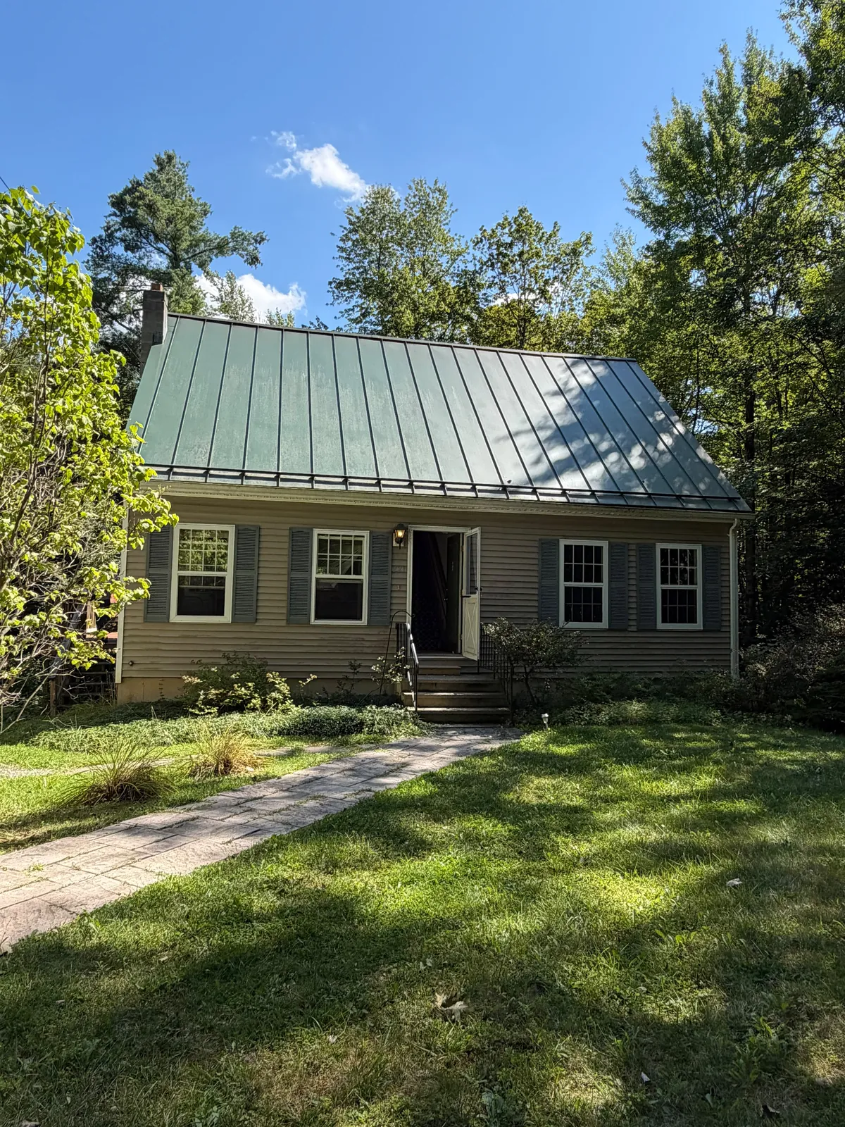 House with a metal roof and front yard