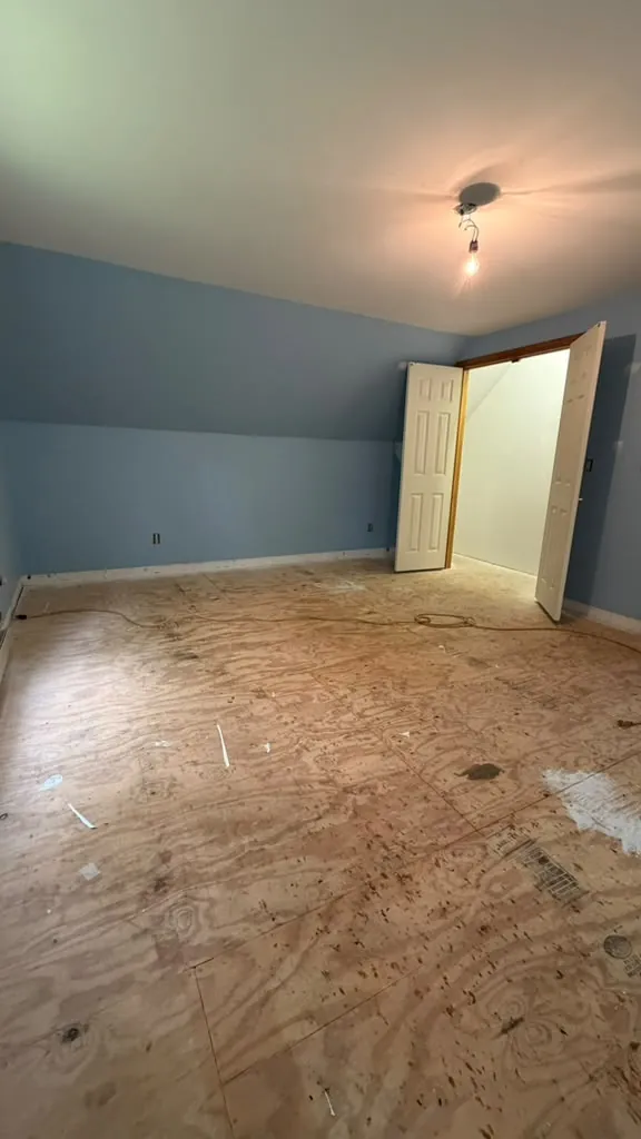 Attic bedroom with exposed subfloor and light blue walls